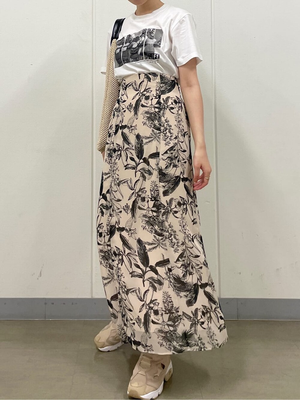 ベージュ系のスニーカー、ホワイト系のTシャツ/カットソー、ベージュ系のスカートを着用したレディースの夏コーディネートの4枚目の写真