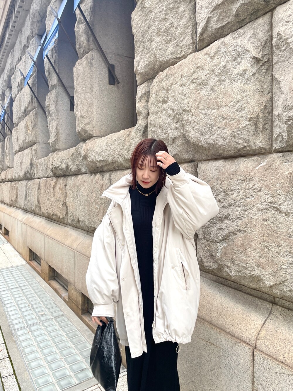 ホワイト系のダウンジャケット/コート、ブラック系のワンピースを着用したレディースの冬コーディネートの5枚目の写真