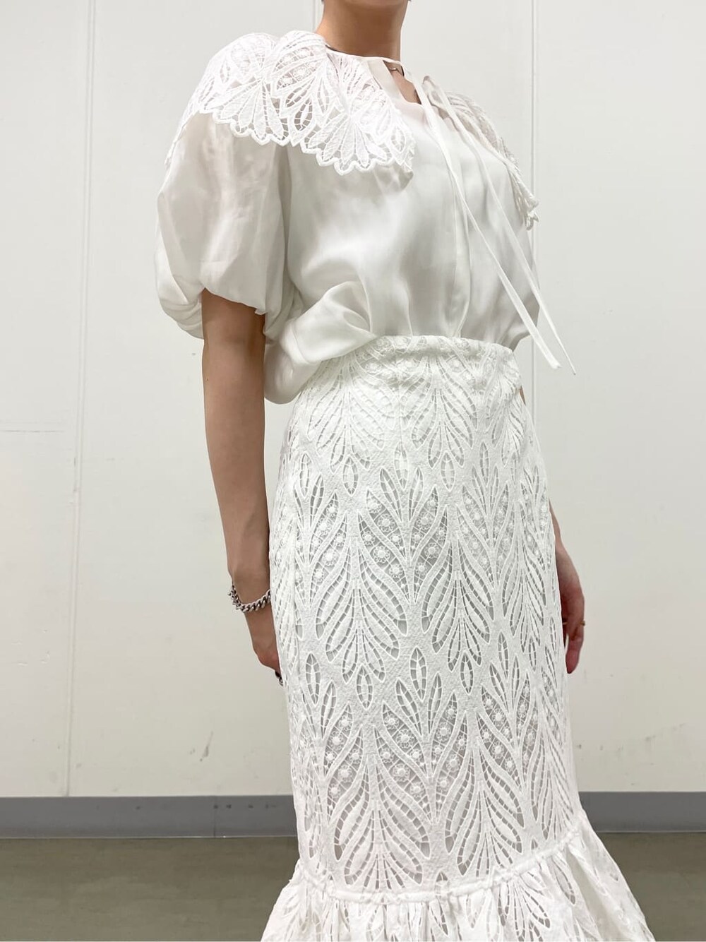 ホワイト系のシャツ/ブラウス、ベージュ系のスニーカー、ホワイト系のスカートを着用したレディースの春コーディネートの4枚目の写真