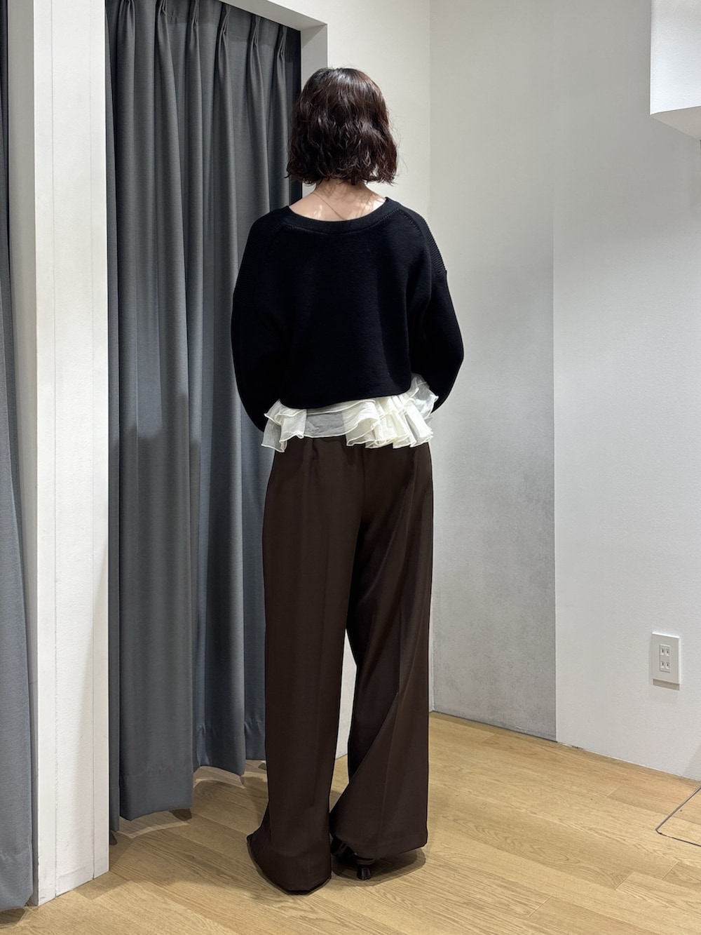 ブラウン系のその他パンツ、ブラック系のカーディガン/ボレロ、レッド系のハンドバッグを着用したレディースの秋コーディネートの4枚目の写真