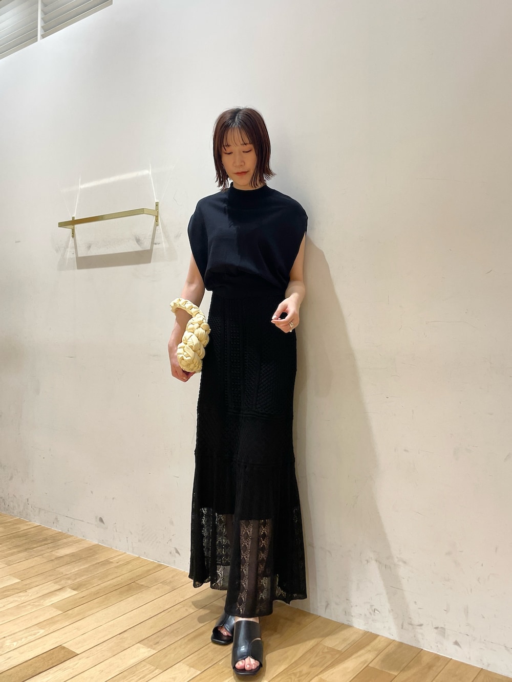 ベージュ系のハンドバッグ、ブラック系のサンダル、ブラック系のニット/セーターを着用したレディースの夏コーディネートの3枚目の写真