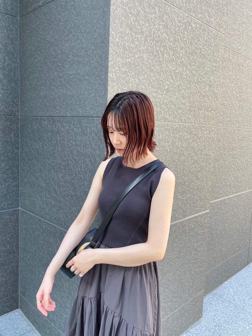 ブラック系のサンダル、グレー系のワンピース、ブラック系のショルダーバッグを着用したレディースの夏コーディネートの5枚目の写真