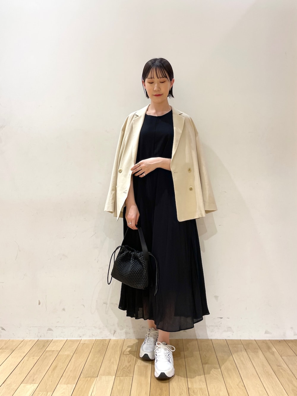 ブラック系のワンピース、ブラック系のハンドバッグ、ブラウン系のサンダルを着用したレディースの夏コーディネートの2枚目の写真