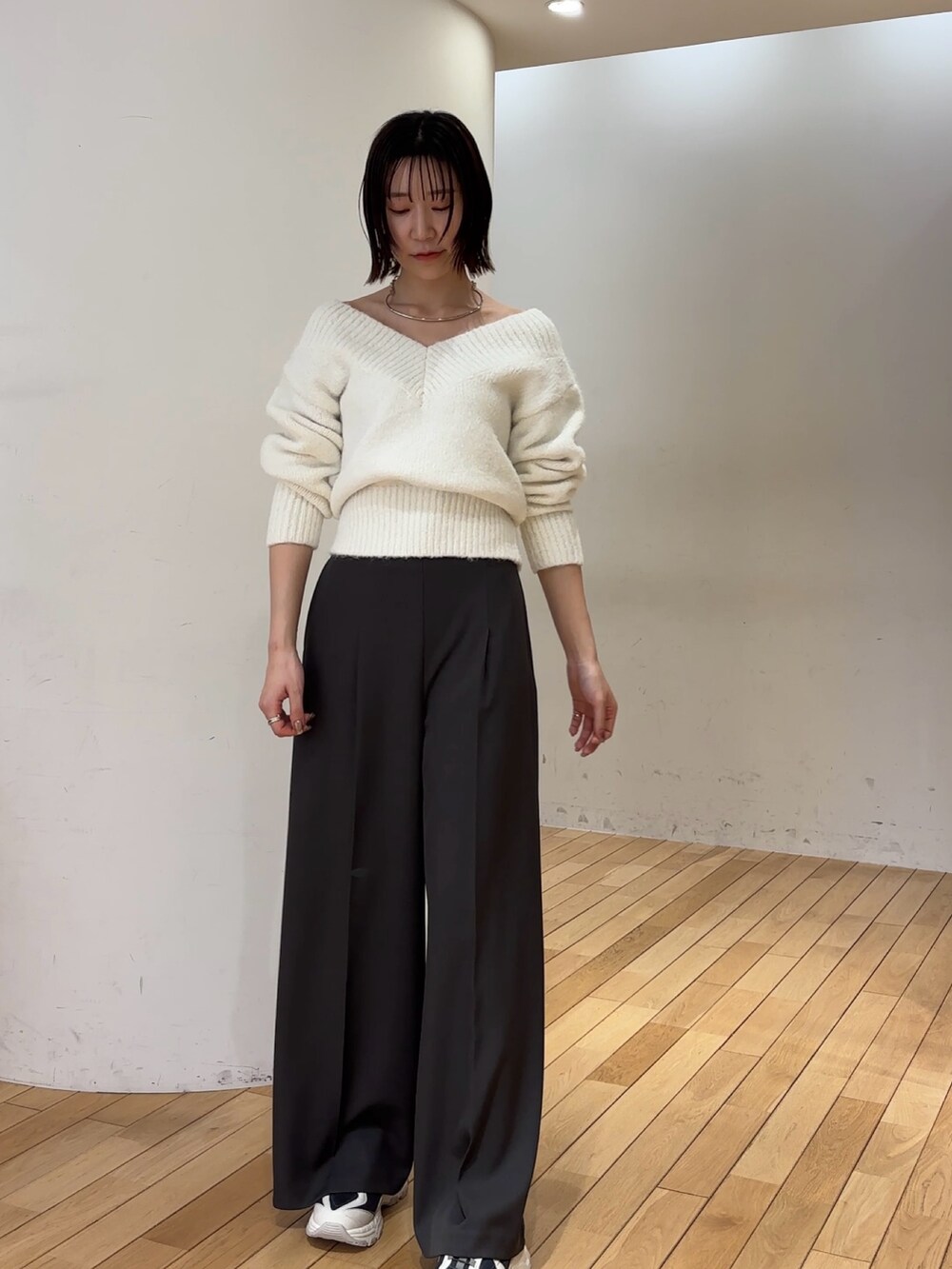 グレー系のその他パンツ、ホワイト系のニット/セーター、グレー系のスニーカーを着用したレディースの冬コーディネートの2枚目の写真