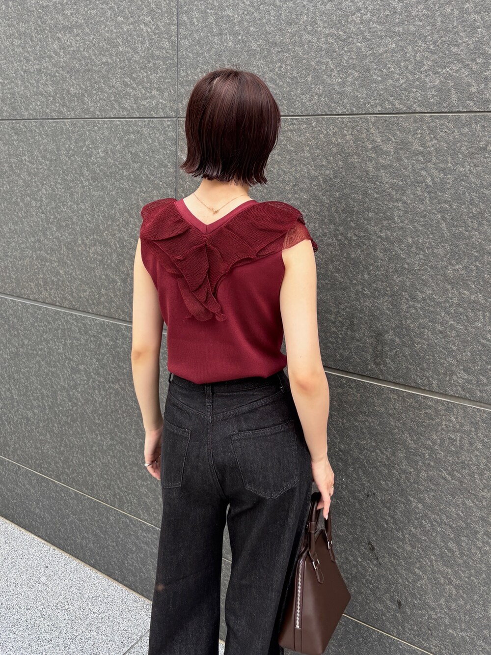 ブラウン系のボストンバッグ、ブラック系のデニムパンツ、ブラウン系のパンプスを着用したレディースの夏コーディネートの5枚目の写真