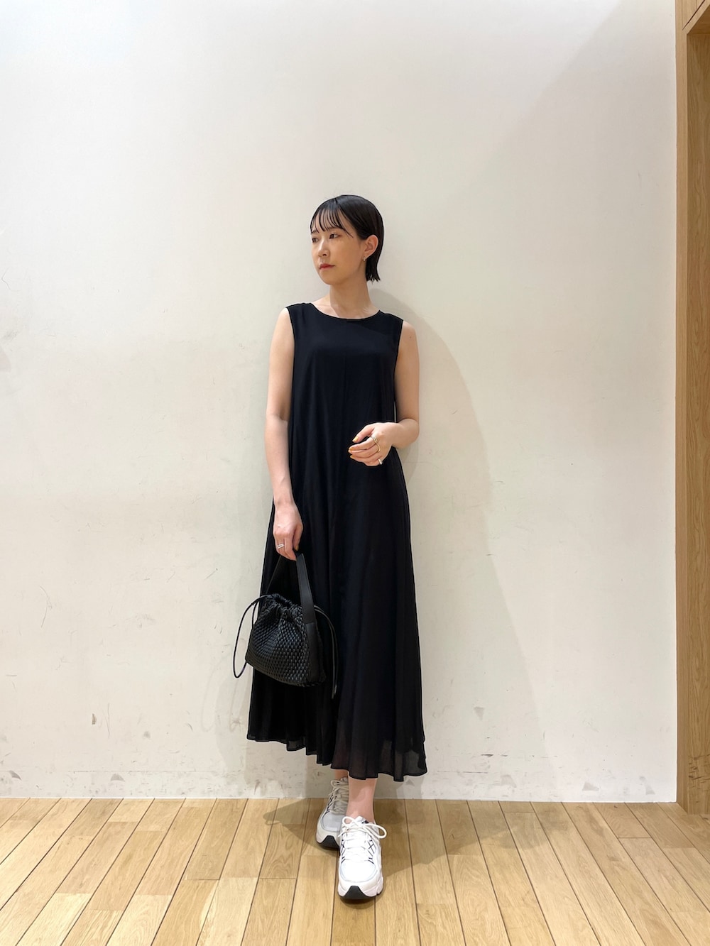 ブラック系のワンピース、ブラック系のハンドバッグ、ブラウン系のサンダルを着用したレディースの夏コーディネートの3枚目の写真