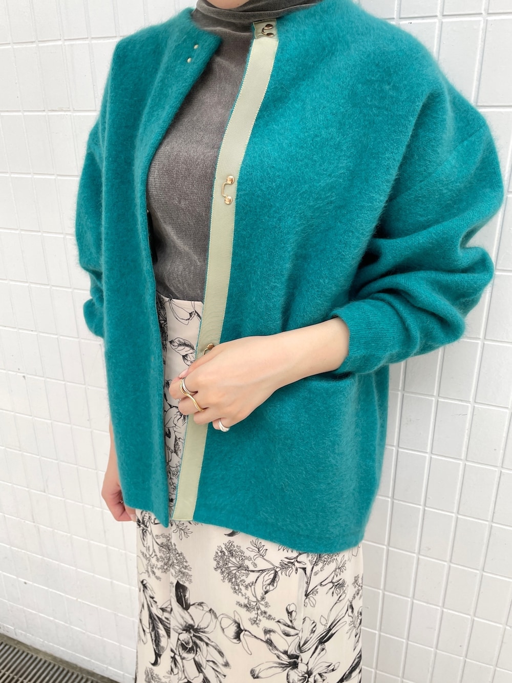 グレー系のTシャツ/カットソー、ホワイト系のスカート、ブラック系のブーツを着用したレディースの秋コーディネートの7枚目の写真