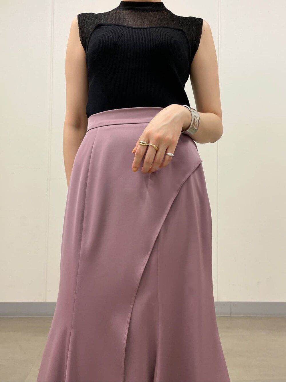 ピンク系のスカート、ホワイト系のサンダル、ブラック系のニット/セーターを着用したレディースの夏コーディネートの6枚目の写真