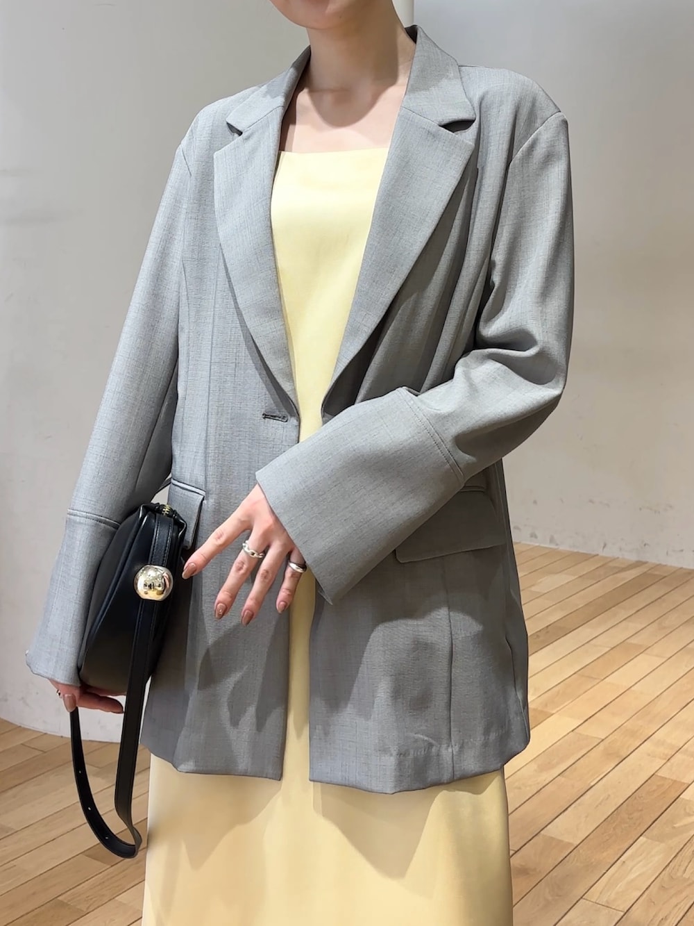 ホワイト系のワンピース、ホワイト系のテーラードジャケット、ブラック系のショルダーバッグを着用したレディースの春コーディネートの5枚目の写真