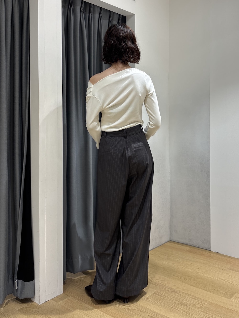 グレー系のその他パンツ、ホワイト系のニット/セーター、レッド系のハンドバッグを着用したレディースの秋コーディネートの9枚目の写真