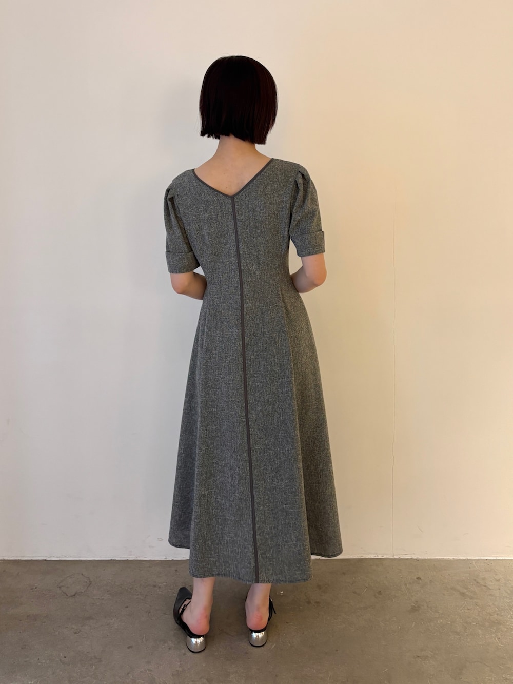 ブラック系のワンピース、ブラック系のパンプスを着用したレディースの春コーディネートの3枚目の写真