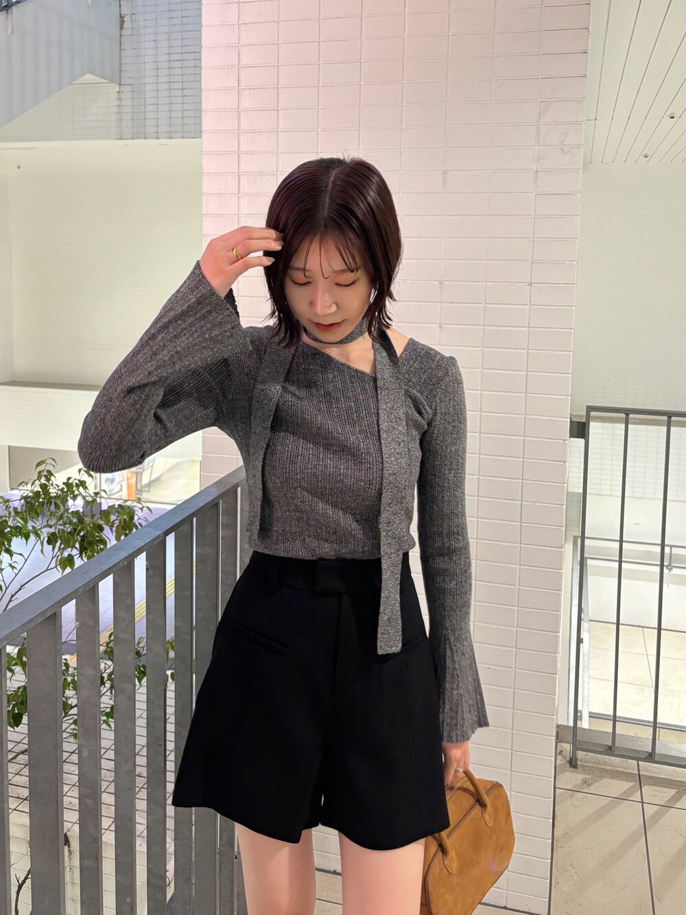 グレー系のニット/セーター、ブラウン系のブルゾン、ブラウン系のボストンバッグを着用したレディースの秋コーディネートの7枚目の写真