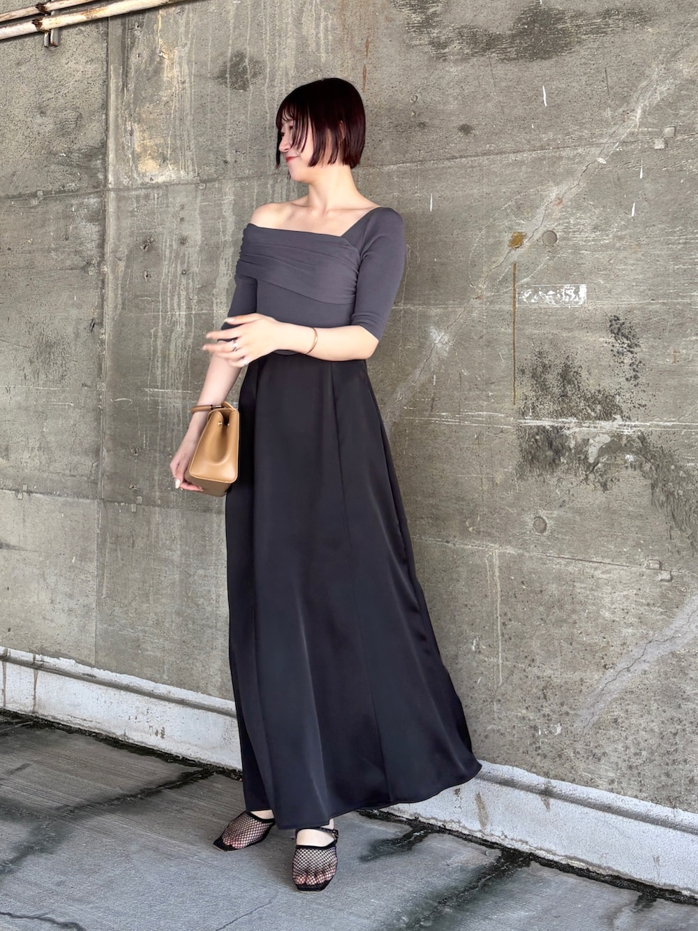 ブラック系のワンピース、ブラック系のサンダル、イエロー系のハンドバッグを着用したレディースの夏コーディネートの2枚目の写真