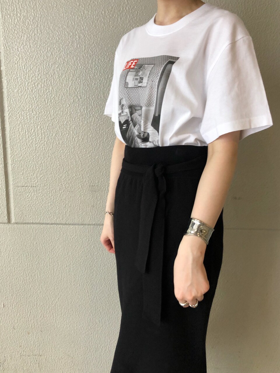 ブラック系のスカート、ブラック系のその他シューズ、ホワイト系のTシャツ/カットソーを着用したレディースの夏コーディネートの4枚目の写真