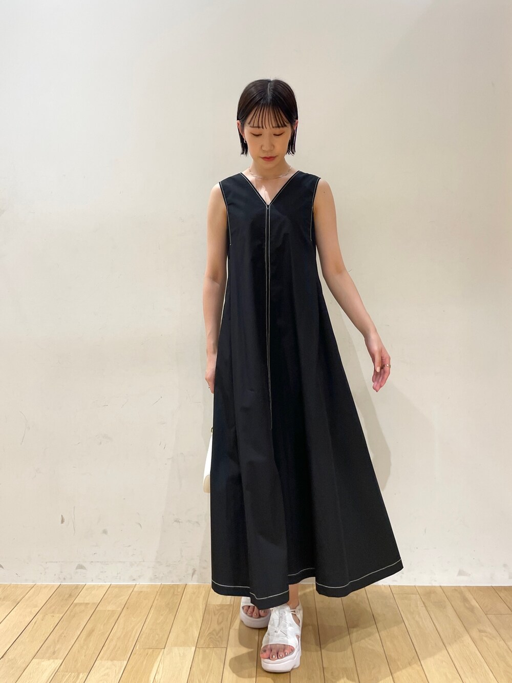 ブラック系のワンピース、ホワイト系のハンドバッグ、ホワイト系のネックレスを着用したレディースの夏コーディネートの4枚目の写真