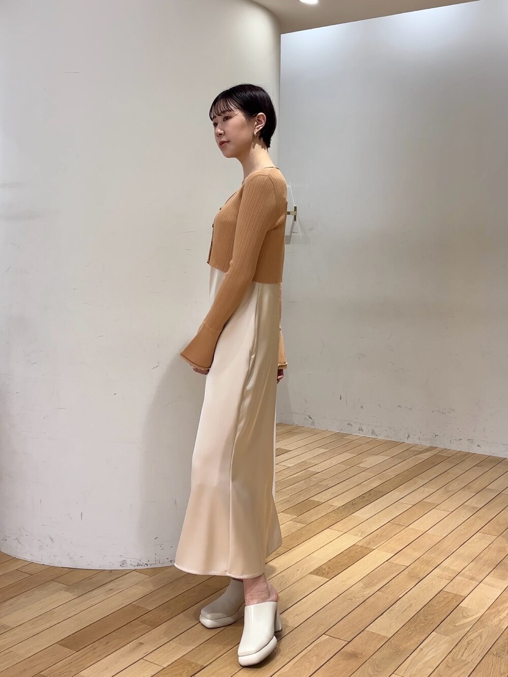 オレンジ系のワンピース、ホワイト系のサンダルを着用したレディースの春コーディネートの2枚目の写真