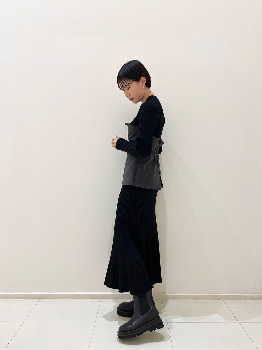 ブラック系のワンピース、ブラック系のブーツを着用したレディースの冬コーディネートの3枚目の写真