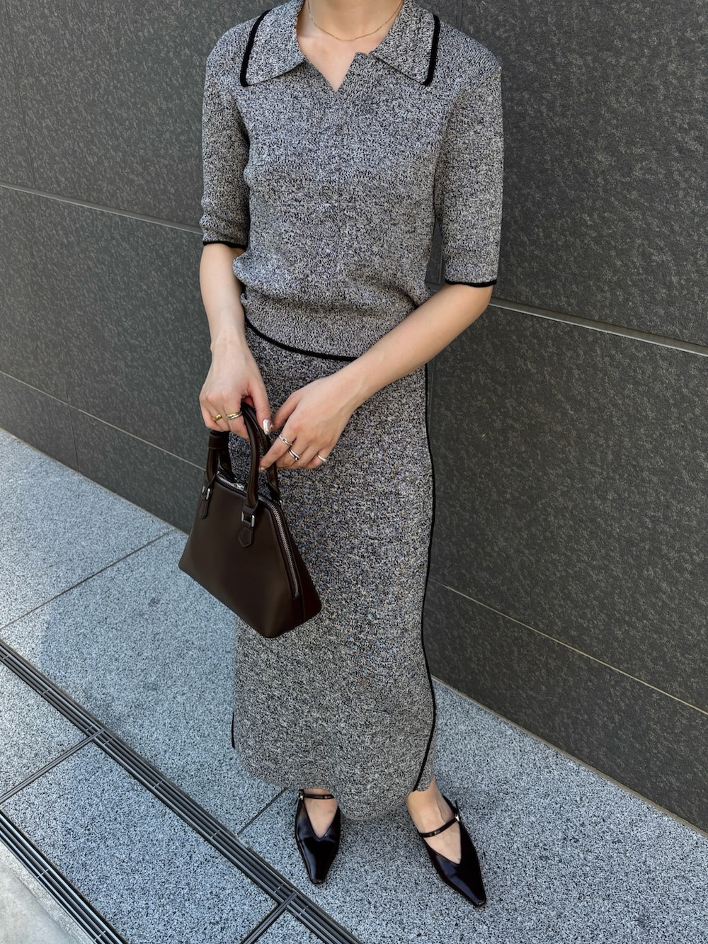 ブラック系のワンピース、ブラウン系のボストンバッグ、ブラウン系のパンプスを着用したレディースの夏コーディネートの6枚目の写真