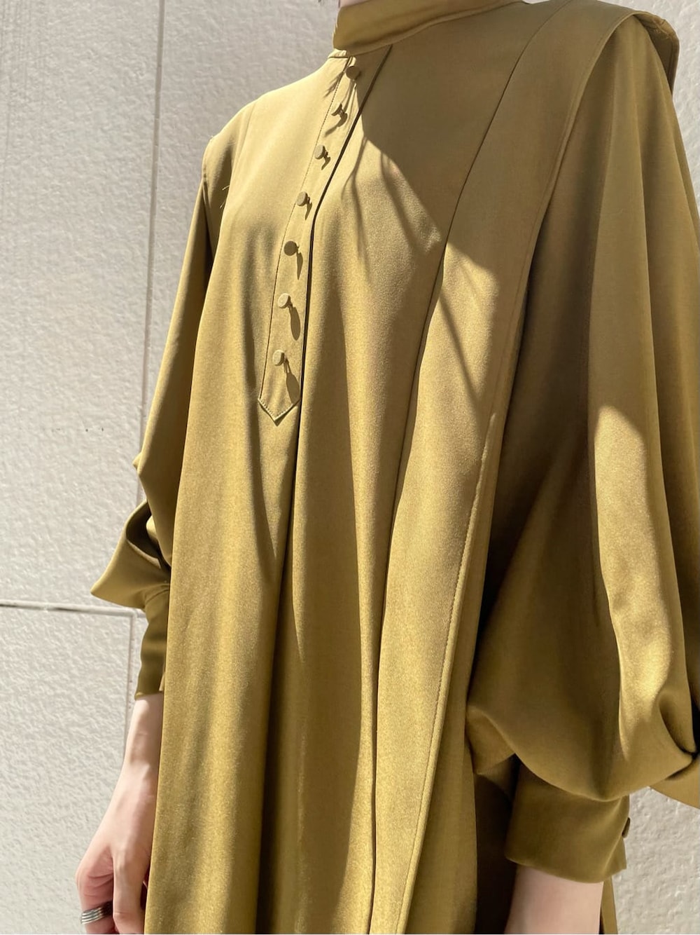 ホワイト系のスカート、ブラック系のその他シューズ、ベージュ系のその他アウターを着用したレディースの秋コーディネートの5枚目の写真