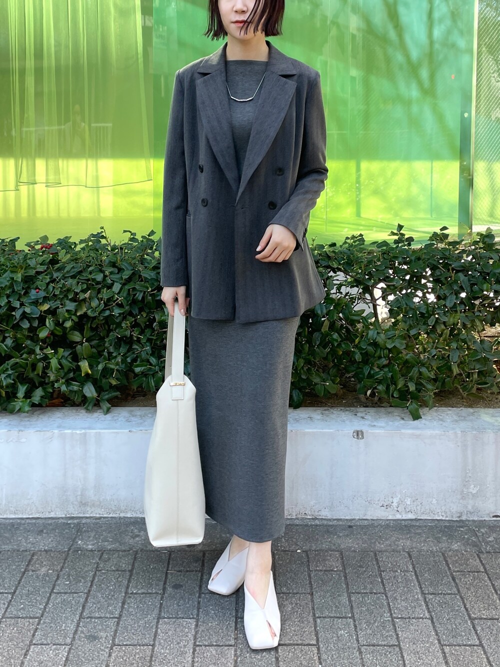 グレー系のワンピース、ホワイト系のショルダーバッグ、ホワイト系のパンプスを着用したレディースの冬コーディネートの8枚目の写真