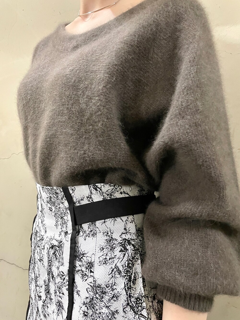 ブラック系のブーツ、ブラウン系のニット/セーター、ブラック系のスカートを着用したレディースの秋コーディネートの7枚目の写真