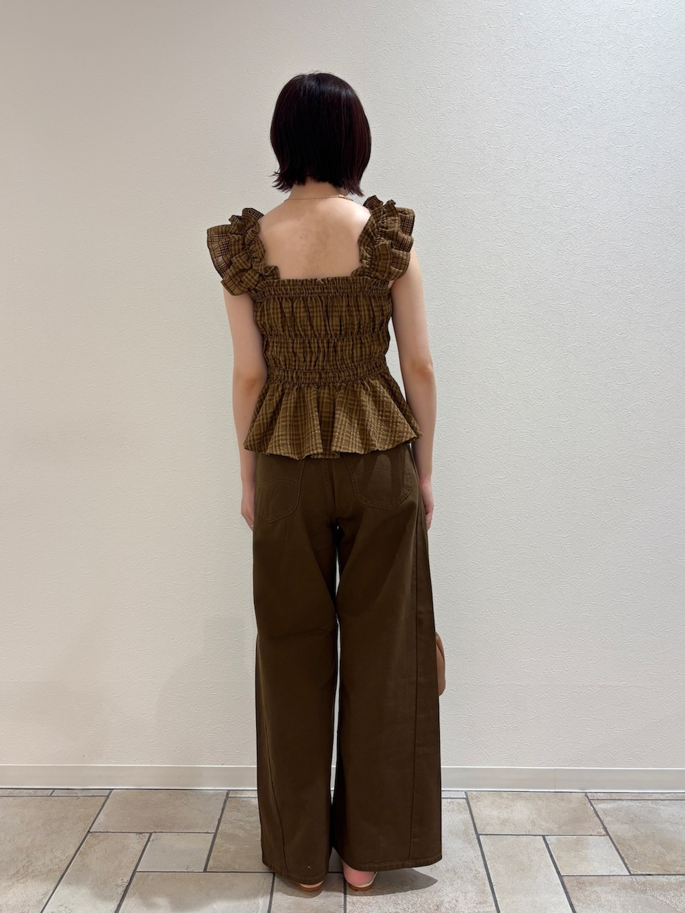 イエロー系のハンドバッグ、ブラウン系のデニムパンツ、ブラウン系のシャツ/ブラウスを着用したレディースの夏コーディネートの3枚目の写真
