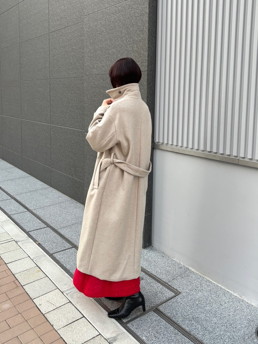 レッド系のワンピース、ホワイト系のチェスターコートを着用したレディースの冬コーディネートの5枚目の写真