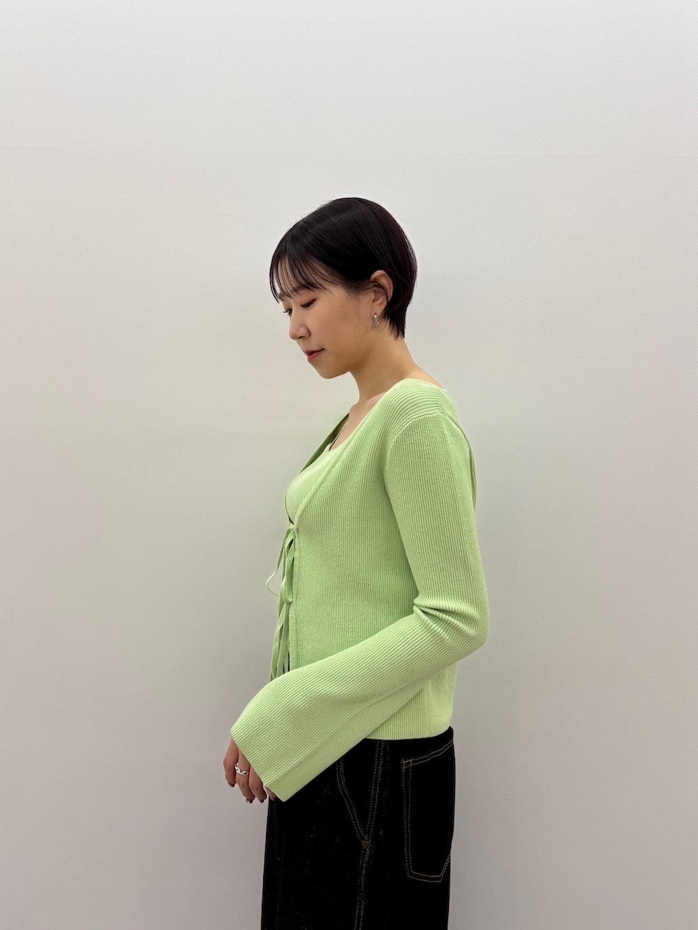 グリーン系のアンサンブル、ブラック系のデニムパンツ、ブラック系のサンダルを着用したレディースの春コーディネートの6枚目の写真