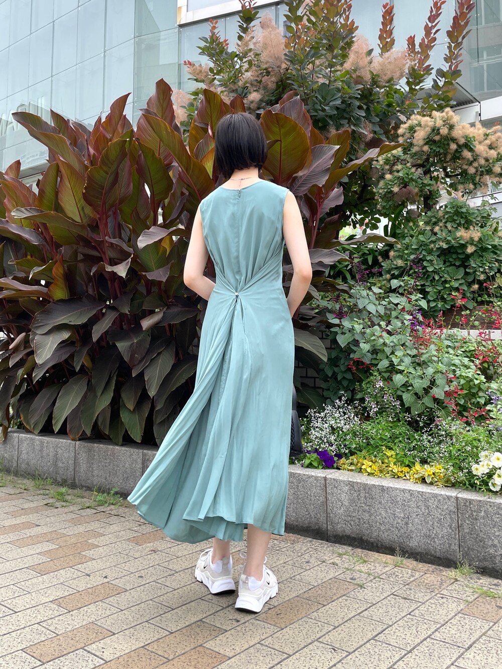 グリーン系のワンピース、ブラック系のハンドバッグを着用したレディースの夏コーディネートの7枚目の写真