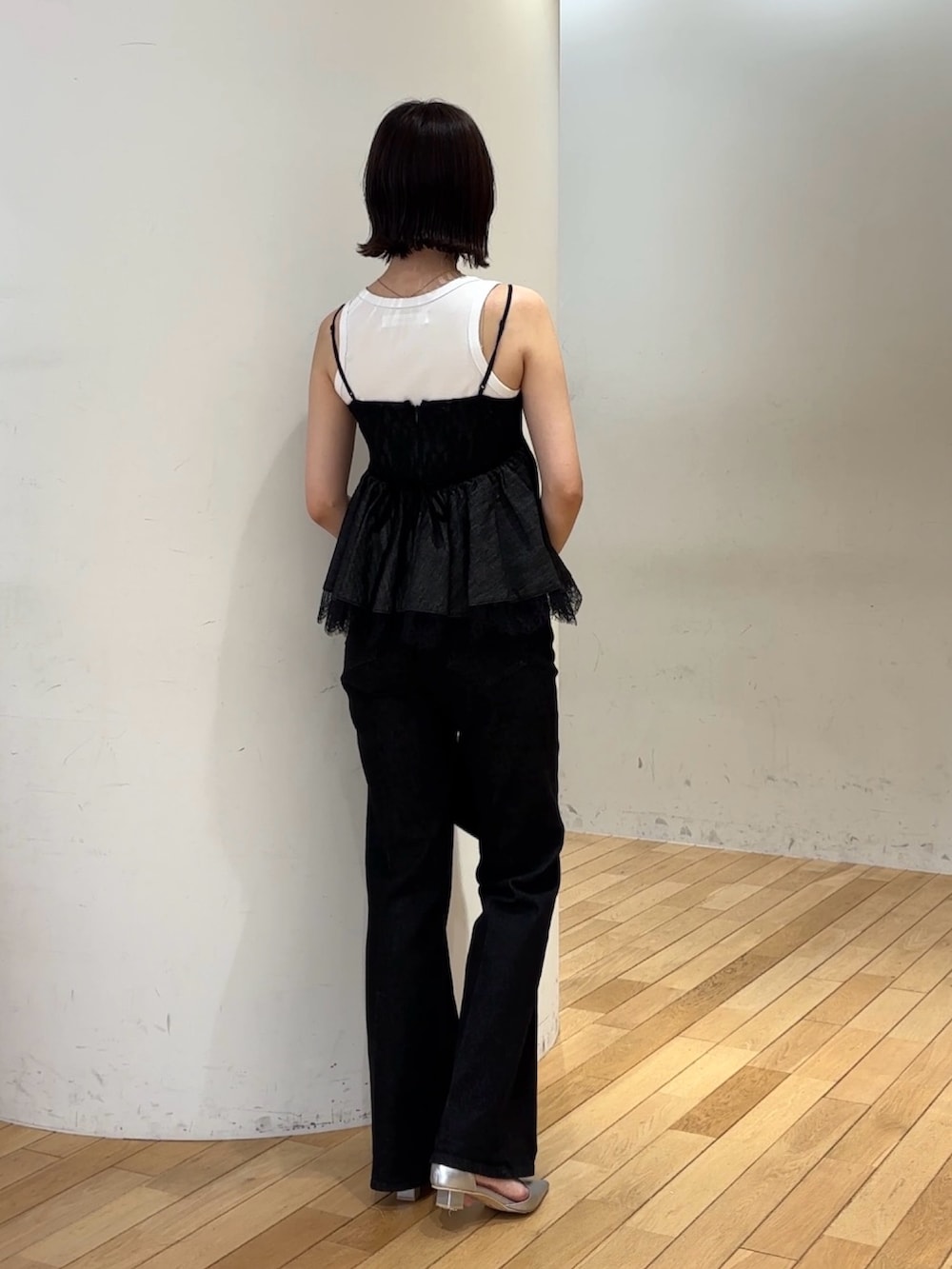 ブラック系のデニムパンツ、シルバー系のパンプス、ホワイト系のタンクトップを着用したレディースの夏コーディネートの4枚目の写真