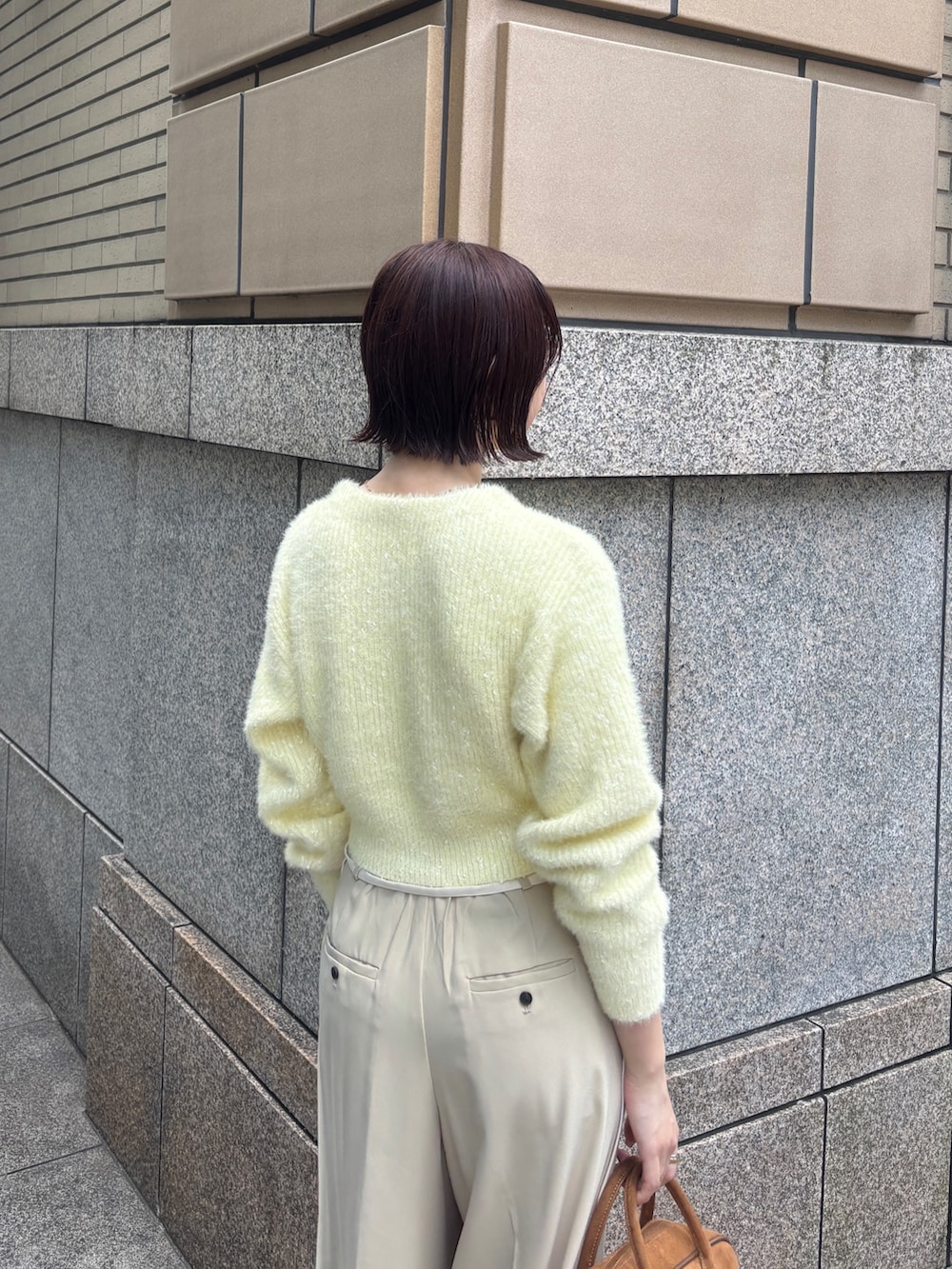 ベージュ系のその他パンツ、イエロー系のカーディガン/ボレロ、イエロー系のハンドバッグを着用したレディースの秋コーディネートの5枚目の写真