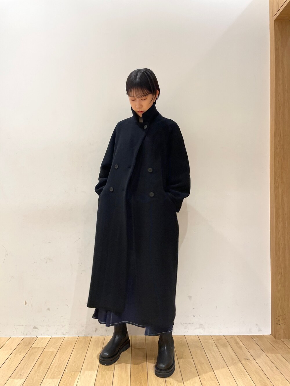 ブラック系のその他アウター、ホワイト系のニット/セーター、ブルー系のスカートを着用したレディースの冬コーディネートの2枚目の写真