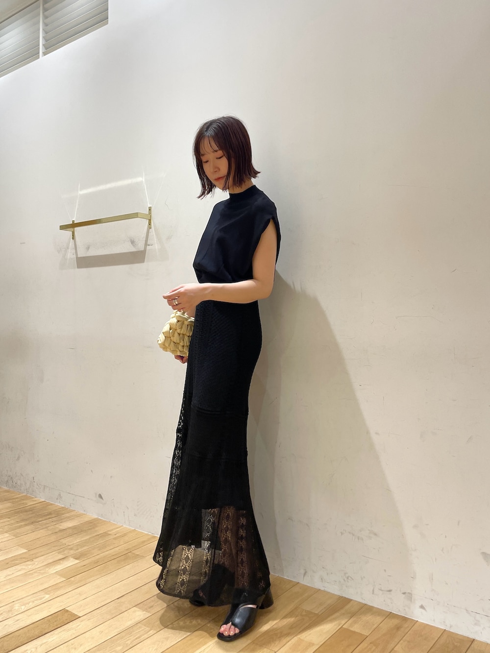 ベージュ系のハンドバッグ、ブラック系のサンダル、ブラック系のニット/セーターを着用したレディースの夏コーディネートの4枚目の写真