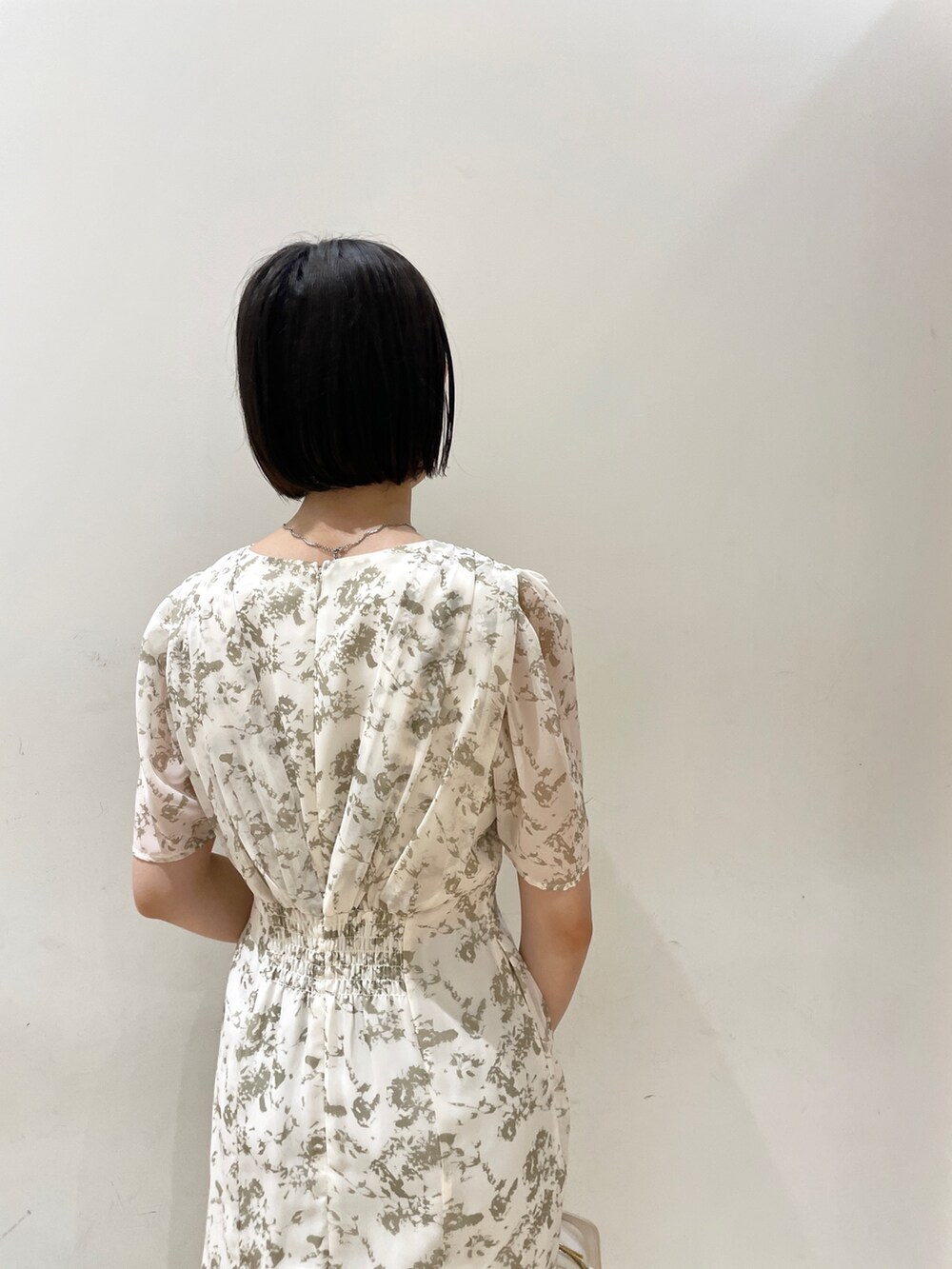 ホワイト系のワンピース、ホワイト系のショルダーバッグ、ベージュ系のサンダルを着用したレディースの夏コーディネートの7枚目の写真