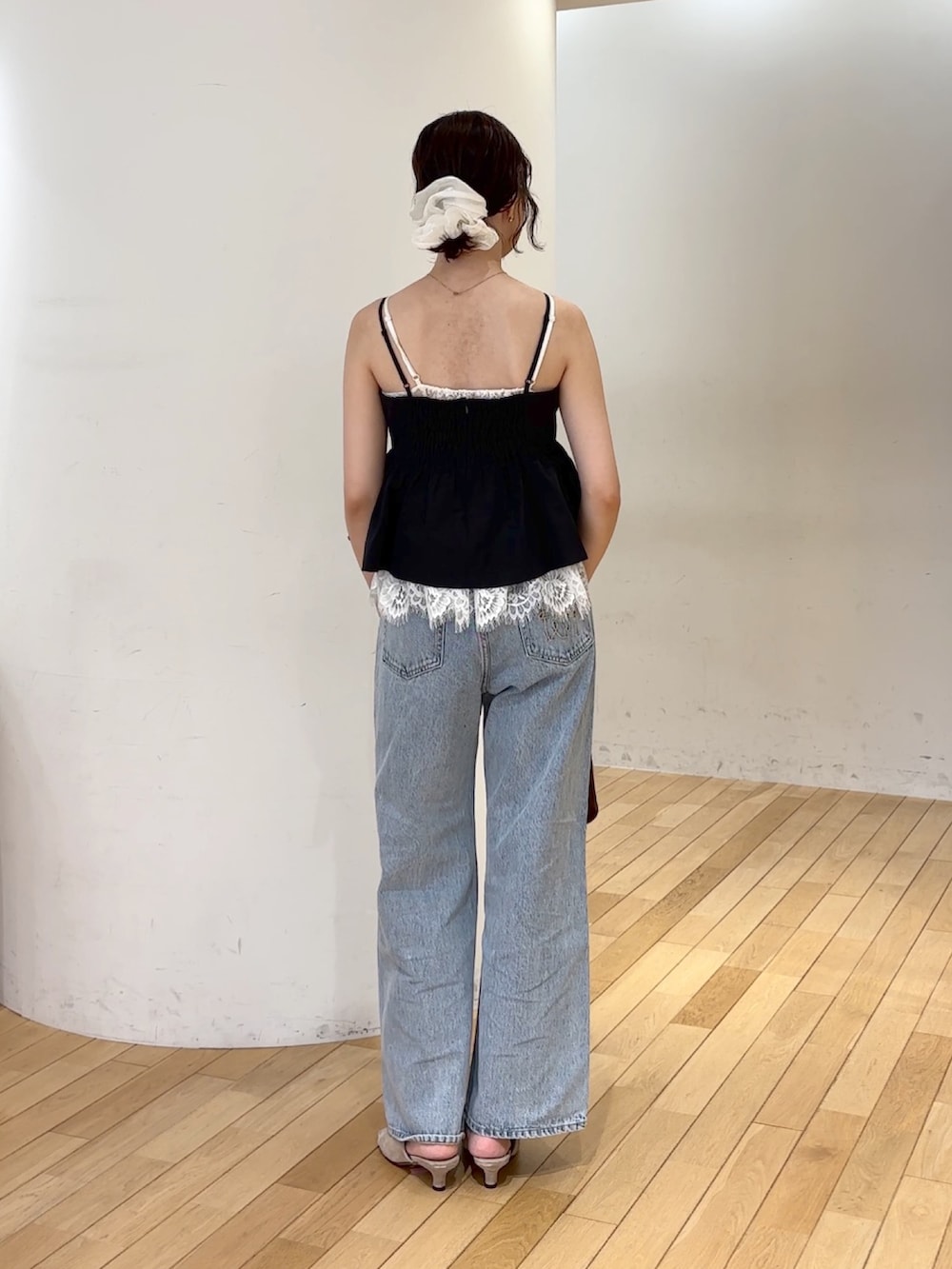 ブラック系のキャミソール、ブルー系のデニムパンツ、ブラウン系のハンドバッグを着用したレディースの夏コーディネートの4枚目の写真