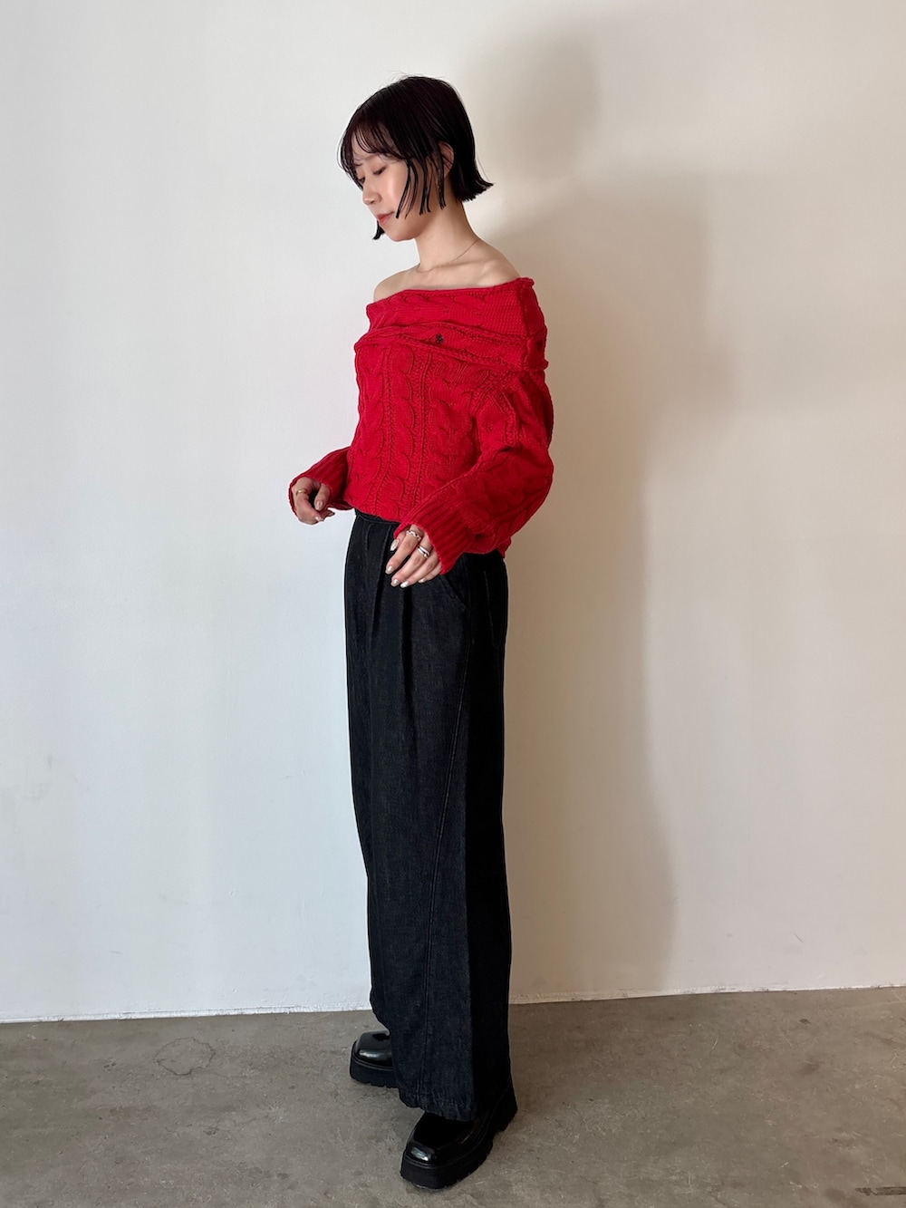 ブラック系のデニムパンツ、レッド系のニット/セーター、ブラック系のローファーを着用したレディースの秋コーディネートの3枚目の写真