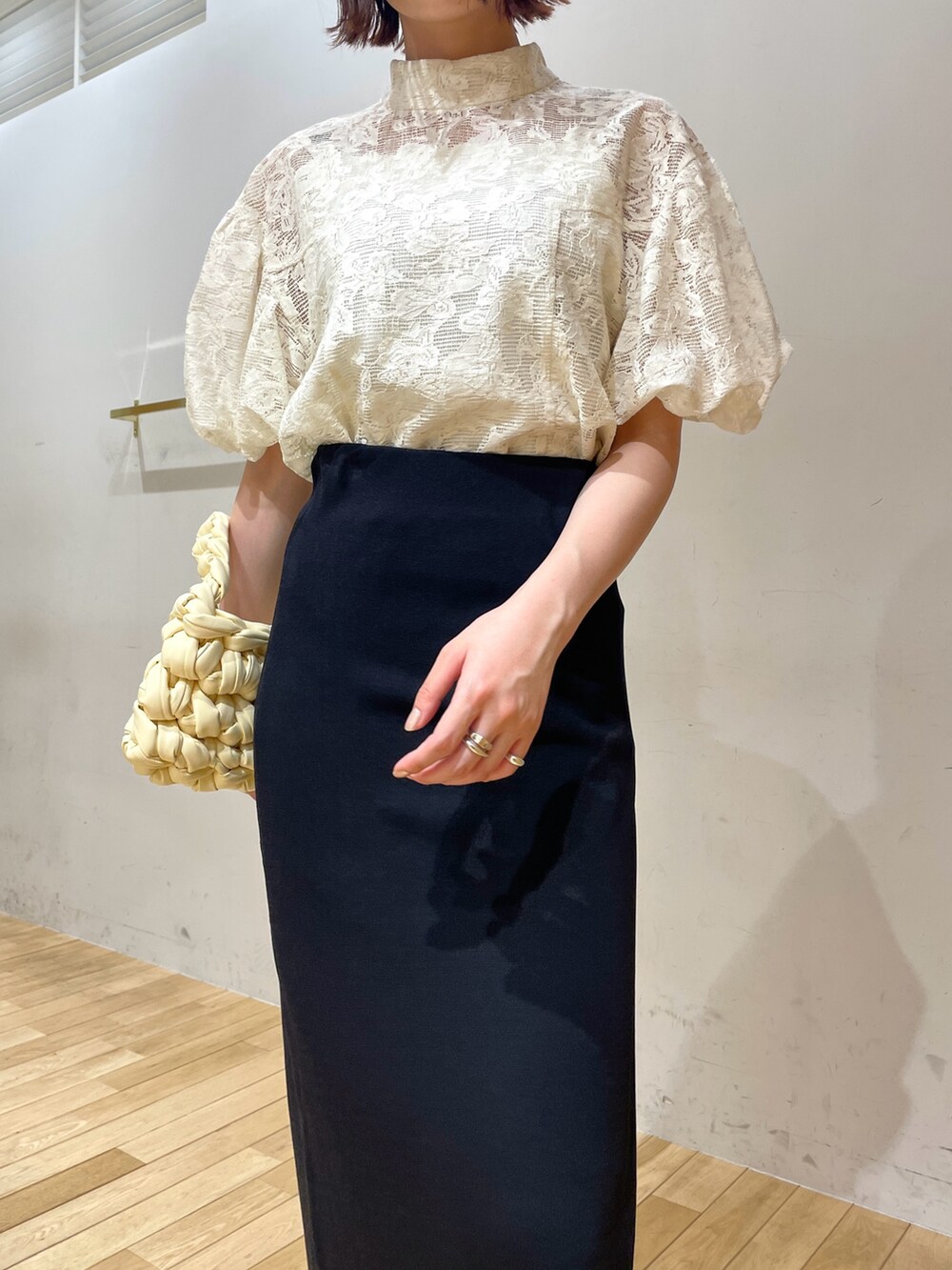 ベージュ系のハンドバッグ、ブラック系のサンダル、ホワイト系のシャツ/ブラウスを着用したレディースの夏コーディネートの6枚目の写真