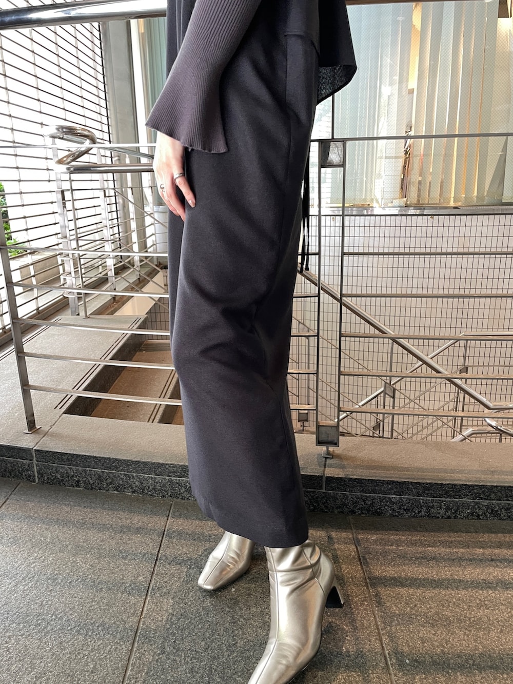 グレー系のニット/セーター、シルバー系のブーツ、ブラック系のワンピースを着用したレディースの秋コーディネートの6枚目の写真