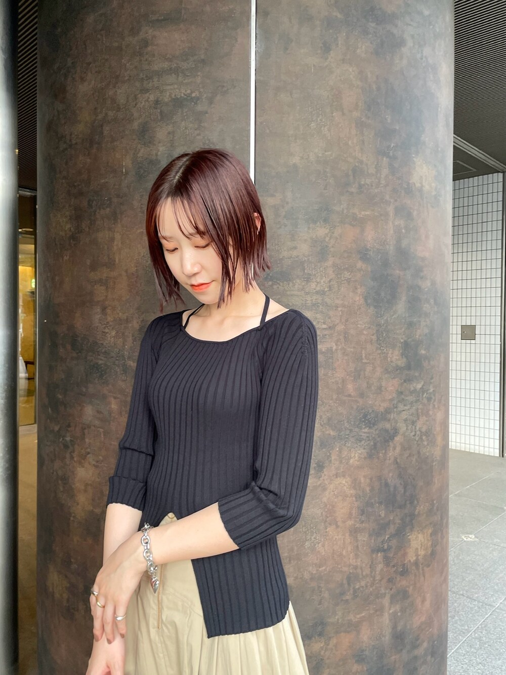 ブラック系のスニーカー、ブラック系のニット/セーター、ベージュ系のスカートを着用したレディースの春コーディネートの7枚目の写真