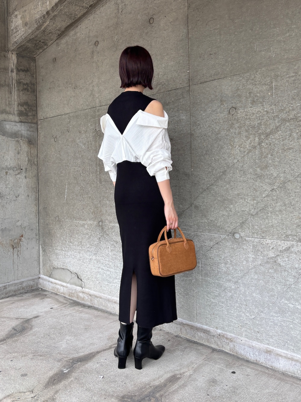 ブラック系のブーツ、イエロー系のハンドバッグ、ブラック系のワンピースを着用したレディースの秋コーディネートの3枚目の写真