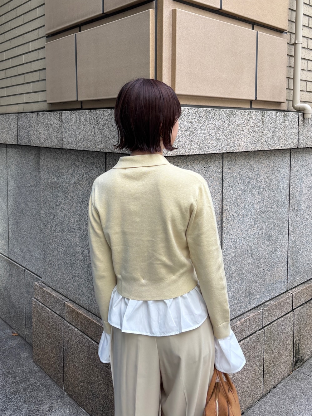 ベージュ系のその他パンツ、イエロー系のハンドバッグ、イエロー系のカーディガン/ボレロを着用したレディースの秋コーディネートの4枚目の写真