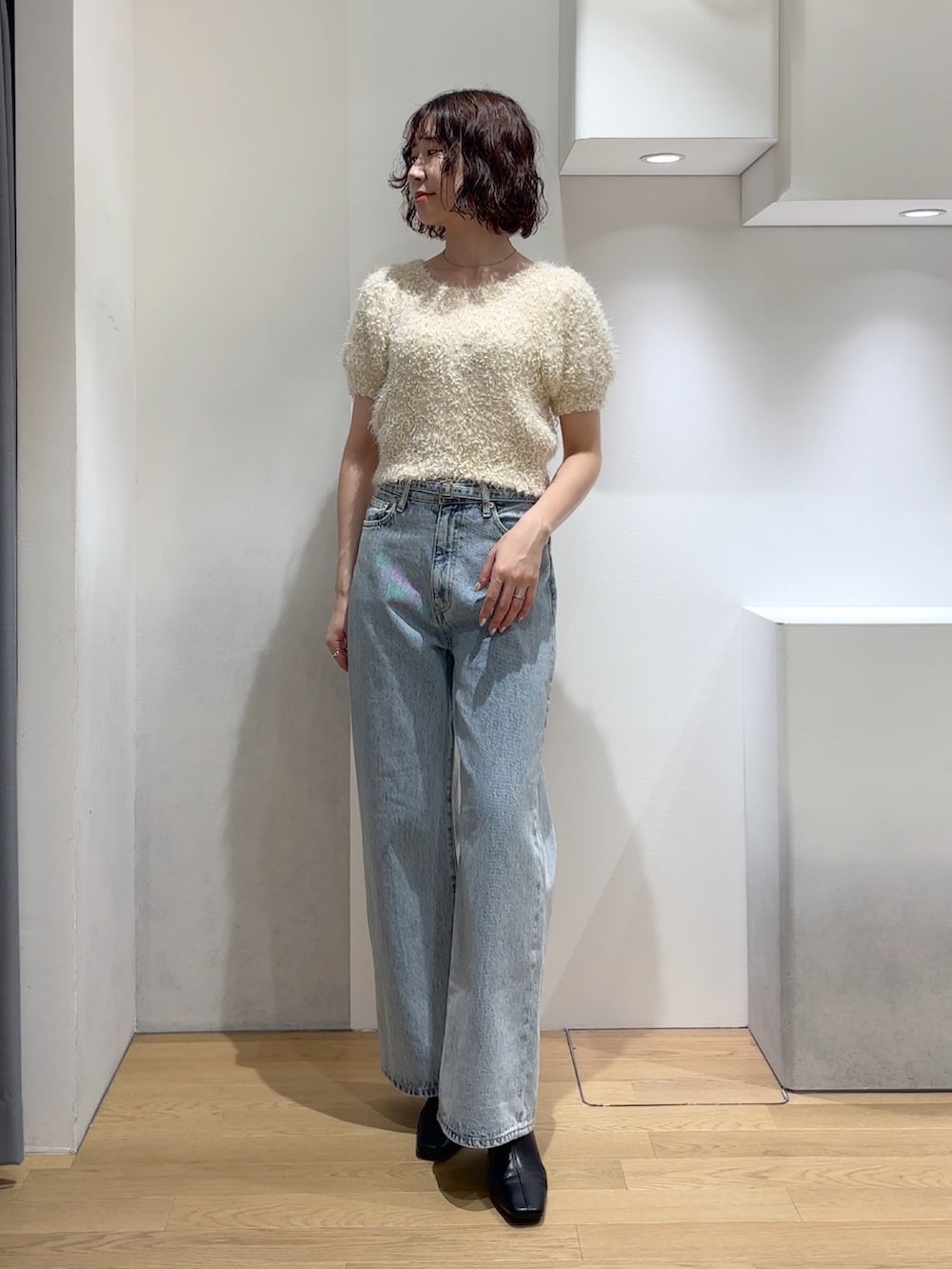 ホワイト系のニット/セーター、ブルー系のデニムパンツ、ブラック系のブーツを着用したレディースの秋コーディネートの7枚目の写真