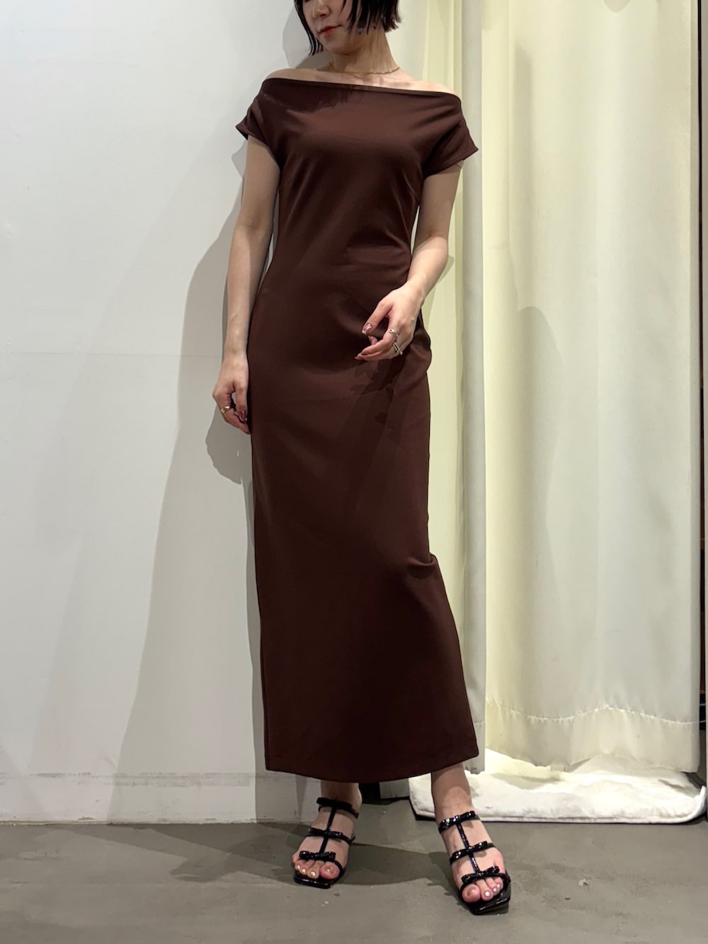 ブラック系のサンダル、ブラウン系のワンピースを着用したレディースの夏コーディネートの2枚目の写真