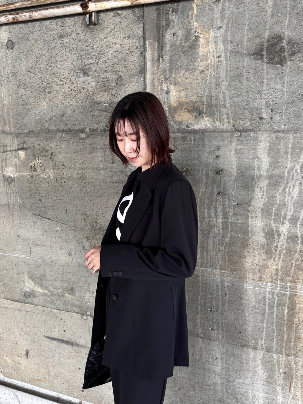 ブラック系のスカート、ブラック系のTシャツ/カットソー、ブラック系のテーラードジャケットを着用したレディースの冬コーディネートの4枚目の写真