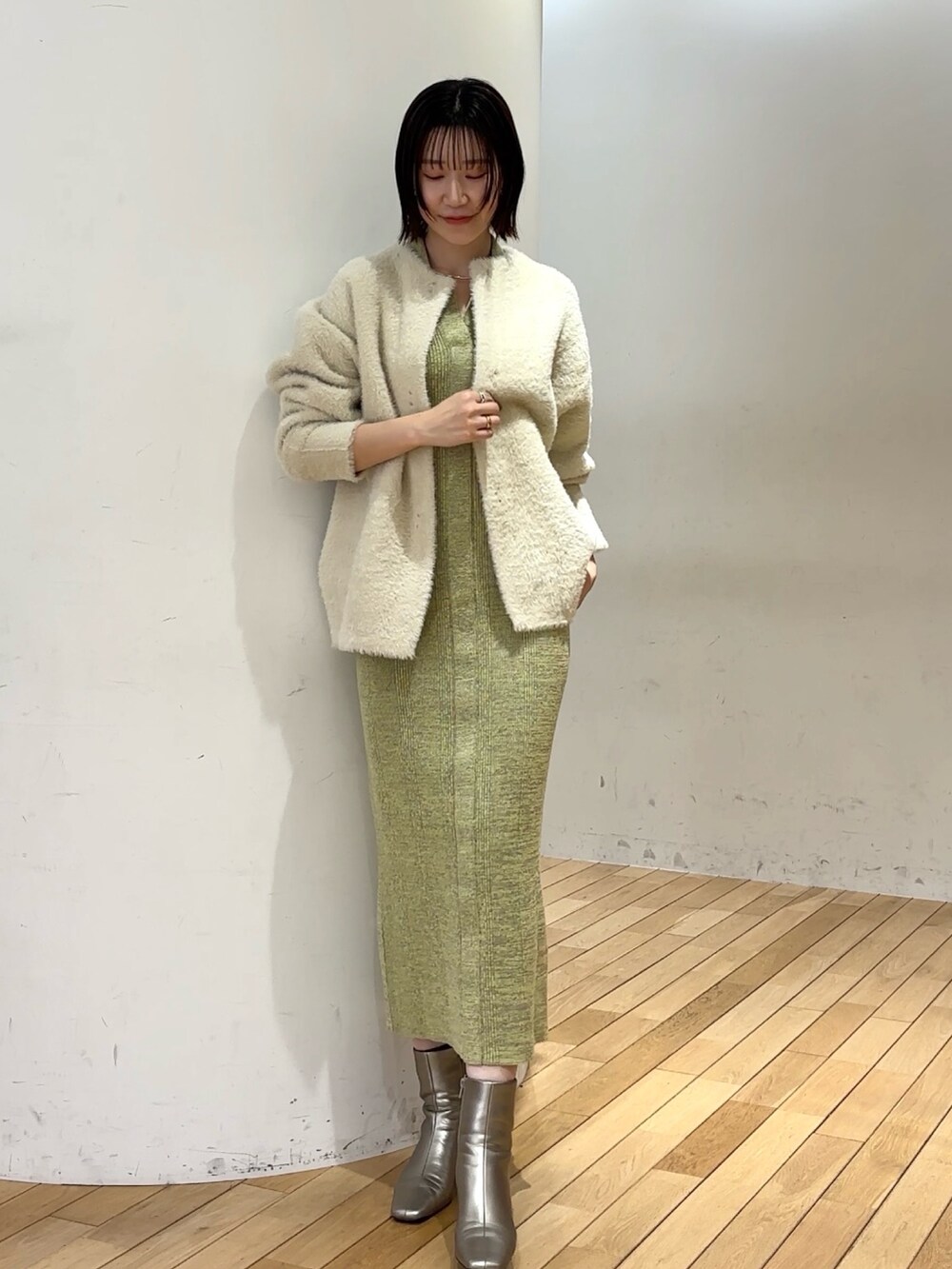 グリーン系のワンピース、シルバー系のブーツを着用したレディースの冬コーディネートの5枚目の写真