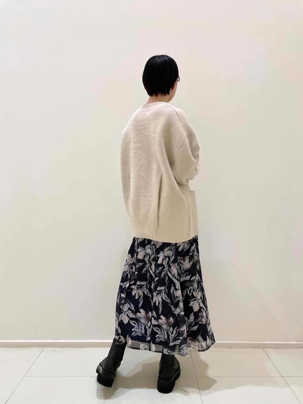 ホワイト系のカーディガン/ボレロ、ブルー系のワンピース、ブラック系のブーツを着用したレディースの冬コーディネートの4枚目の写真