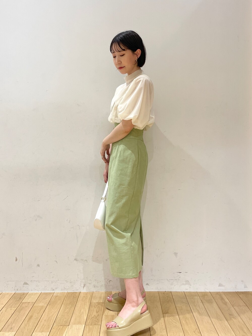 ベージュ系のサンダル、グリーン系のスカート、ホワイト系のシャツ/ブラウスを着用したレディースの夏コーディネートの4枚目の写真