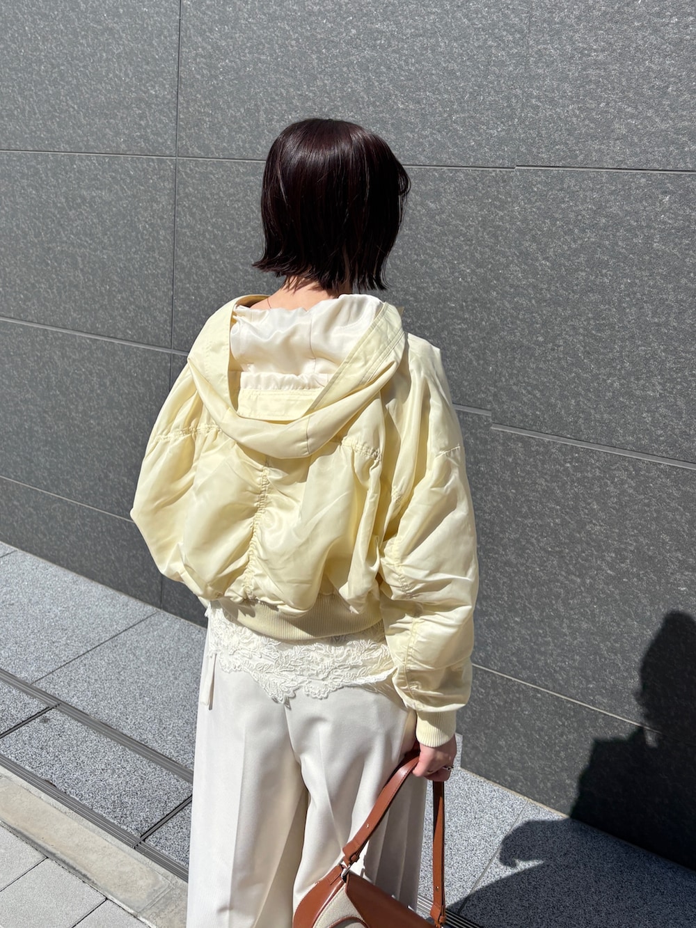 ホワイト系のその他パンツ、ブラウン系のハンドバッグ、イエロー系のブルゾンを着用したレディースの春コーディネートの5枚目の写真