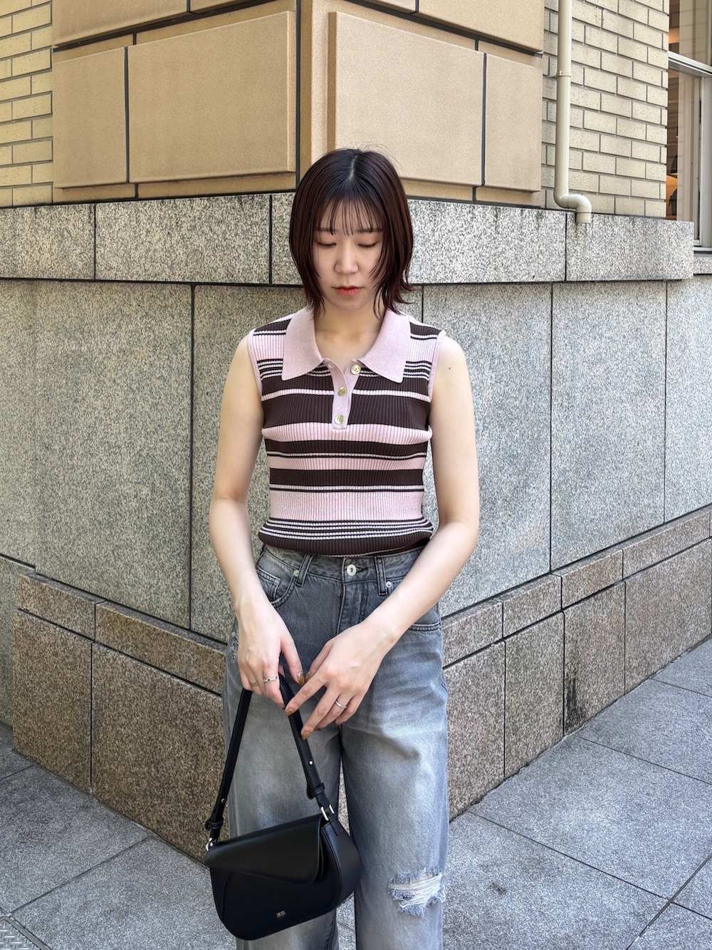 グレー系のデニムパンツ、ピンク系のニット/セーター、ホワイト系のサンダルを着用したレディースの春コーディネートの3枚目の写真