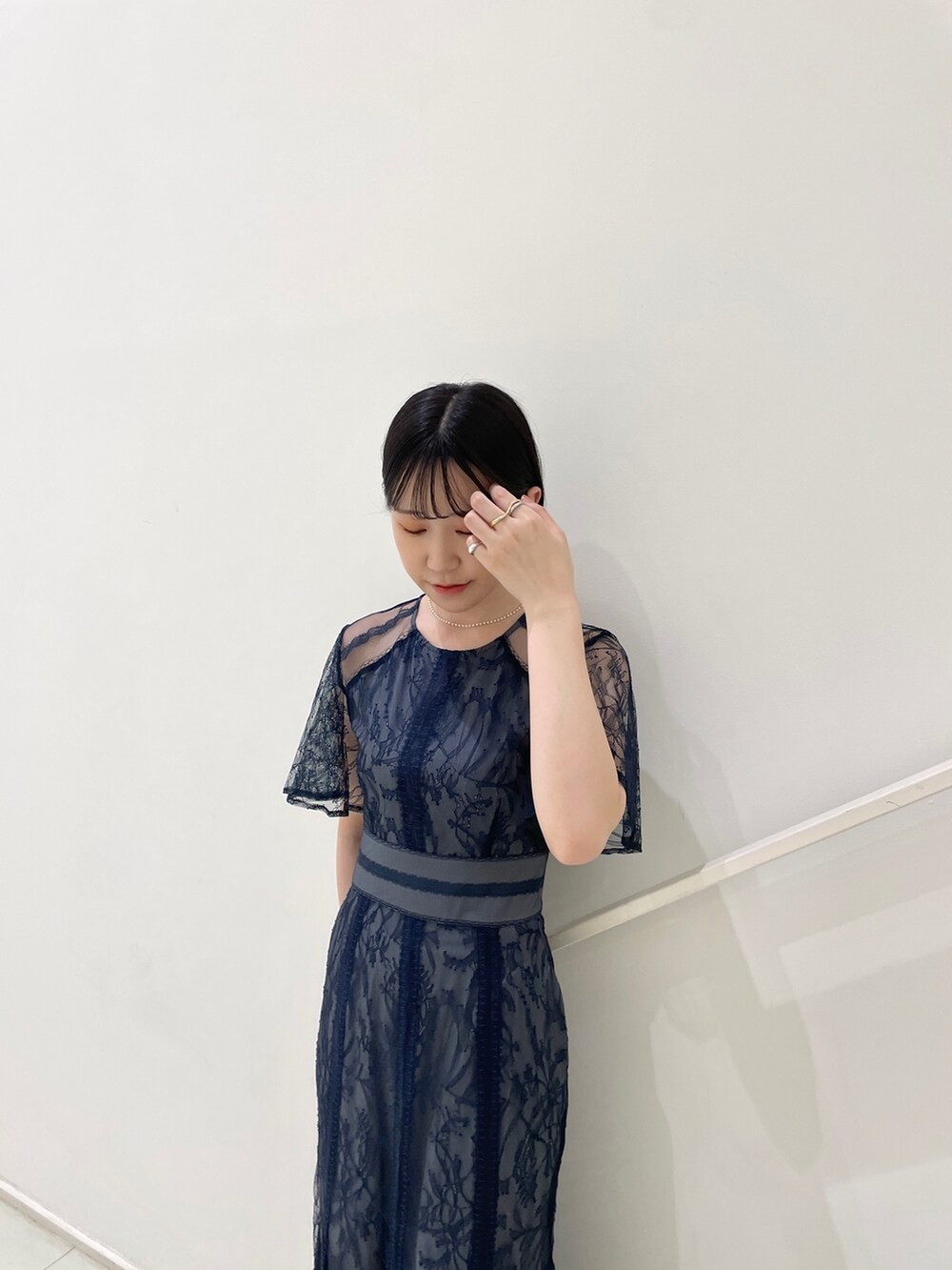 ブルー系のドレス、ゴールド系のパンプス、ホワイト系のネックレスを着用したレディースの春コーディネートの6枚目の写真